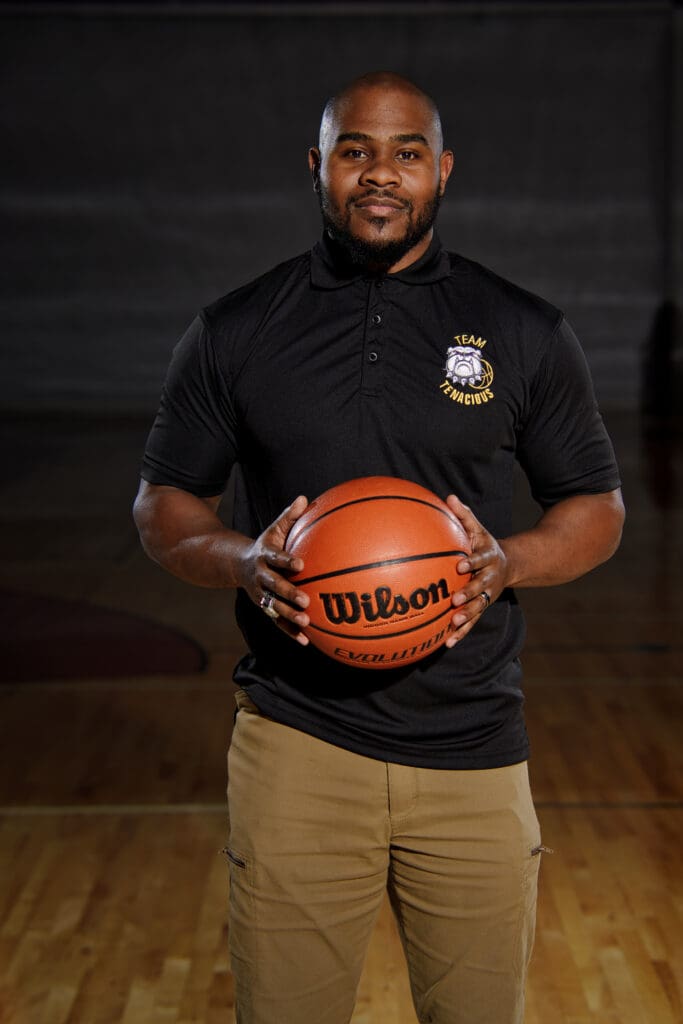 A man holding a basketball in front of him.