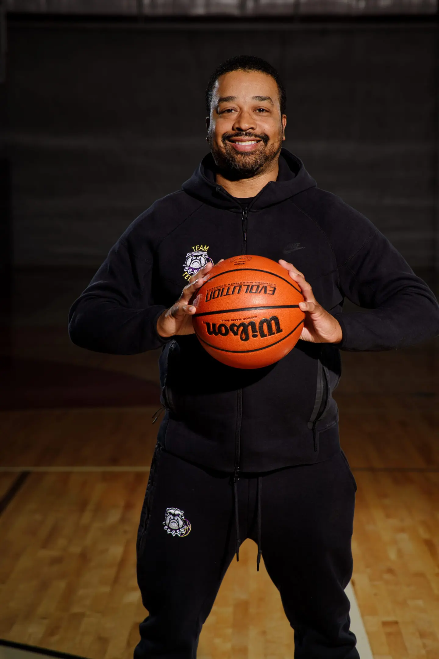 A man holding an orange basketball in his hands.