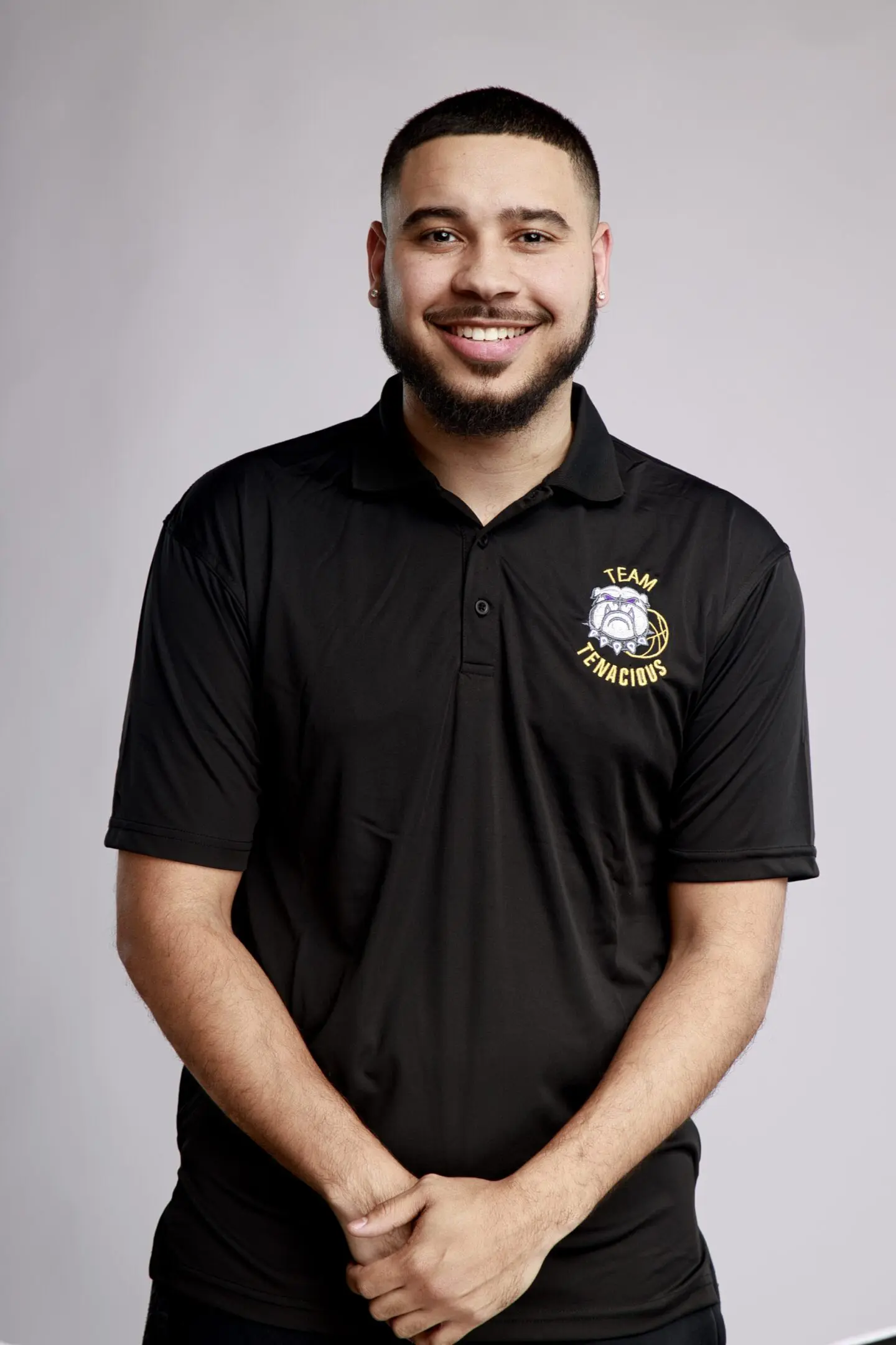 A man in black shirt standing next to wall.